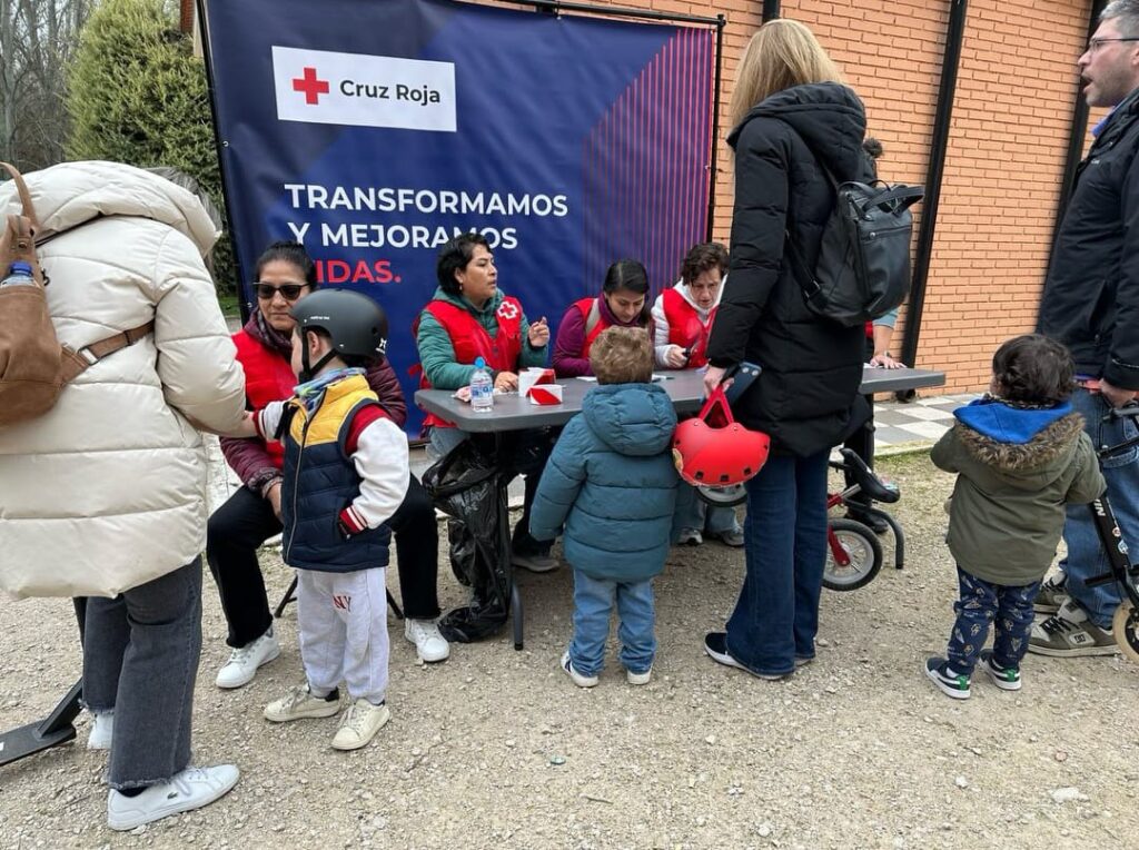 Los voluntarios de Cruz Roja asisten a los participantes en el circuito 'Mini Héroes' de educación vial