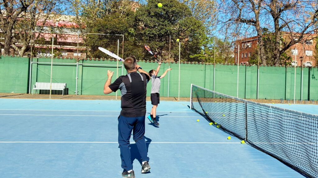 fotografía durante el primer ejercicio de la clase, el calentamiento de activación. Se observa al profesor, Toni López junto a un alumno yendo a golpear una pelota